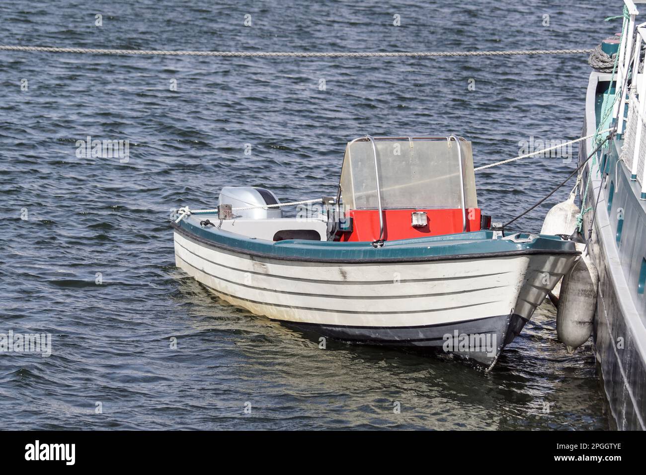 Blick von oben auf das Boot, das neben einem größeren Boot vor Anker liegt Stockfoto