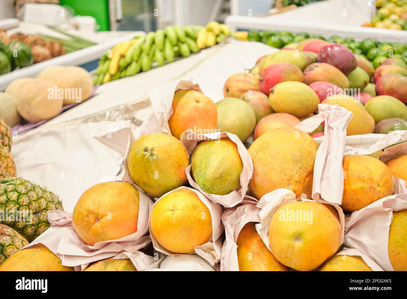 Tropische Früchte zum Verkauf an einem Gemüsemarktstand: Papayas, Mangos, Ananas, Bananen, Melonen. Stockfoto