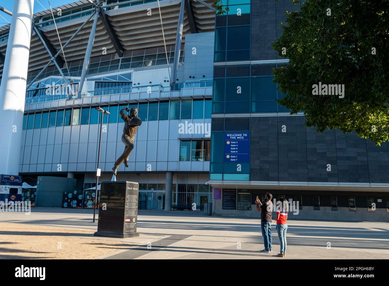 Touristen fotografieren eine Gedenkstatue der Cricket-Legende Shane Warne vor dem MCG in Melbourne, Victoria, Australien Stockfoto