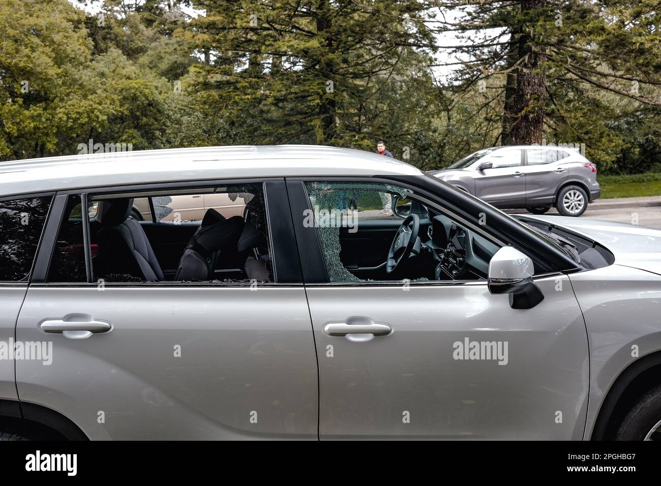 Nahaufnahme eines Autofensters mit einem kleinen kreisförmigen Loch am Boden. Das Glas wurde um das Loch zertrümmert, was auf einen Einbruchversuch hinweist. Autobesitzer in San Francisco sind in höchster Alarmbereitschaft, nach einem plötzlichen Diebstahl von Autofenstern in der Stadt. Diebe brechen in geparkte Autos ein und stehlen wertvolle Gegenstände, was die Autobesitzer frustriert und besorgt über ihre Sicherheit macht. Laut der San Francisco Police Department (SFPD) ist die Zahl der Diebstähle von Autofenstern in den letzten Monaten stark gestiegen. Allein im Februar wurden 423 Fälle von Autoeinbrüchen gemeldet, was einen erheblichen Anstieg darstellt Stockfoto