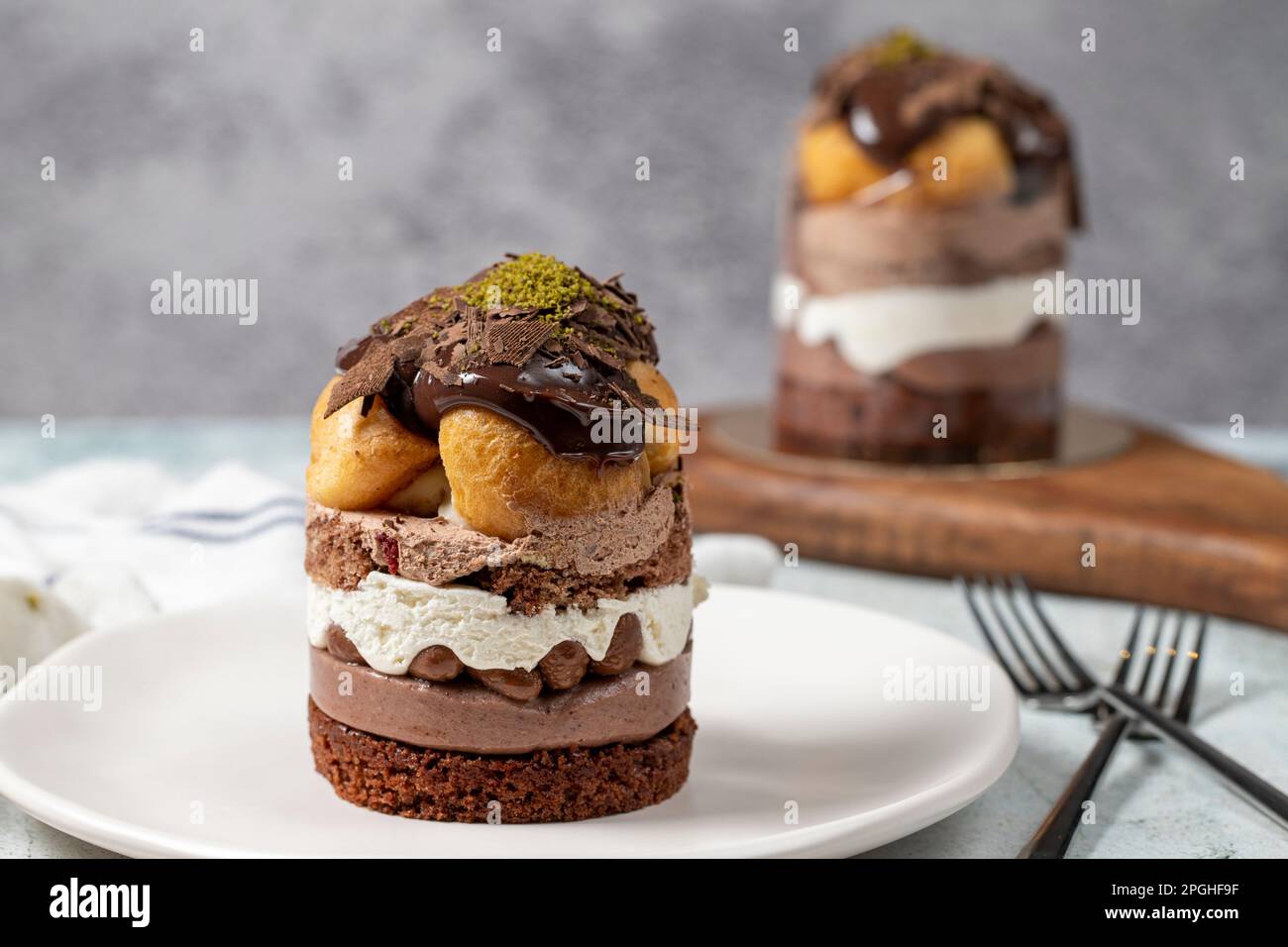 Mehrschichtiger Profiteroles-Kuchen. Schlagsahne, Schokolade und Pistazienkuchen. Schließen. Stockfoto