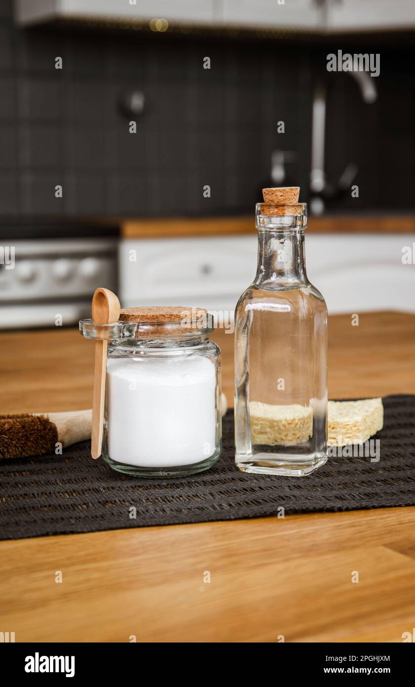 Verwendung von Natronlauge Natriumbicarbonat und Weißessig für die Hausküchenreinigung. Weißer Essig in Glasflasche und Backpulver in Glasbehälter. Stockfoto