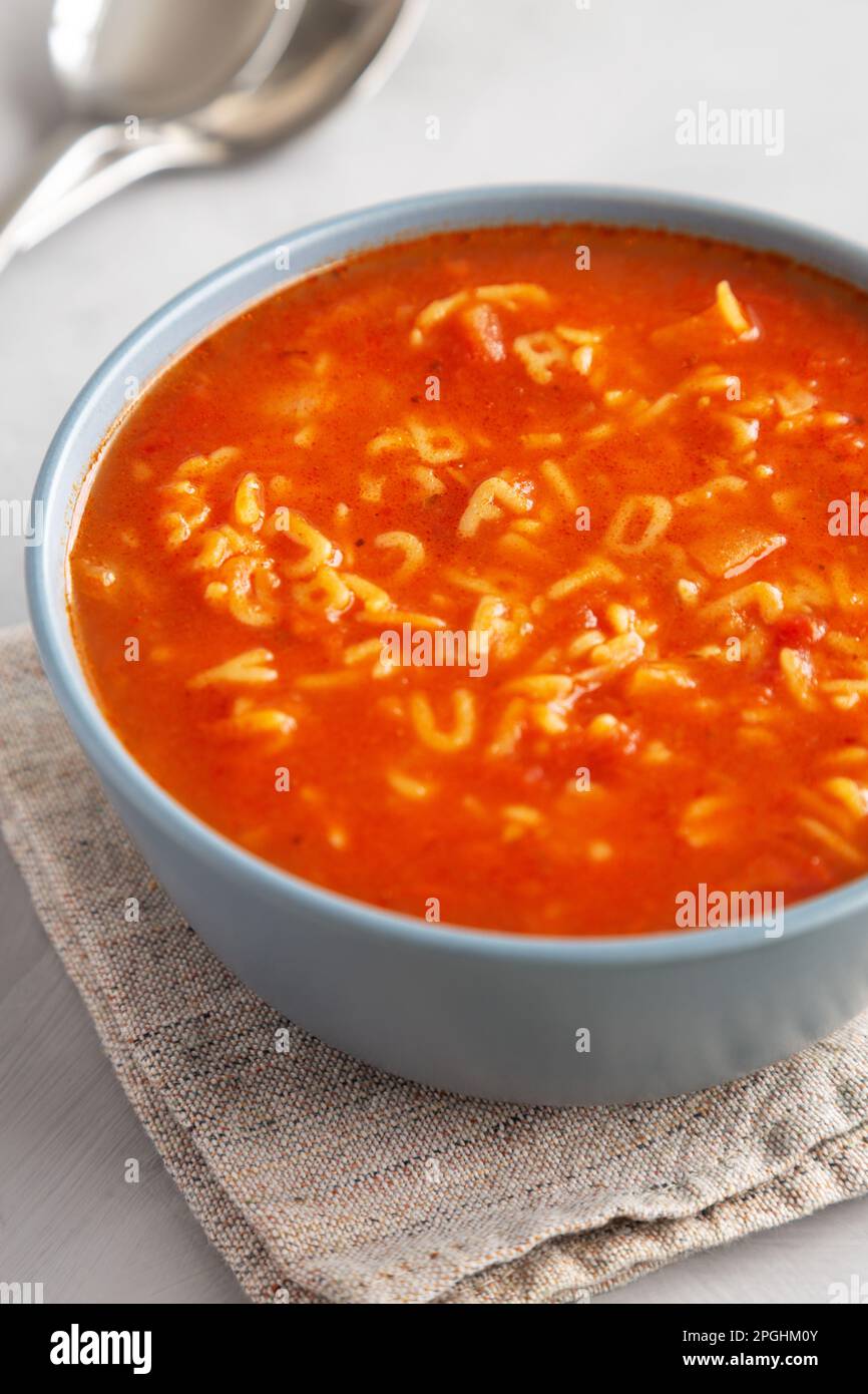 Hausgemachte Alphabet-Suppe in Tomatensauce in einer Schüssel, Seitenansicht. Stockfoto