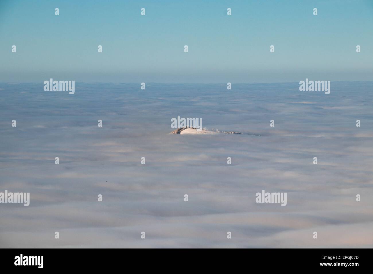 Blick auf den Gipfel des Mount Skalka in den Beskydy Mountains unter dem Deckmantel von dickem weißem Nebel in den Morgenstunden. Schneebedeckte Hügel mit Wolken. Über mir zu sein Stockfoto