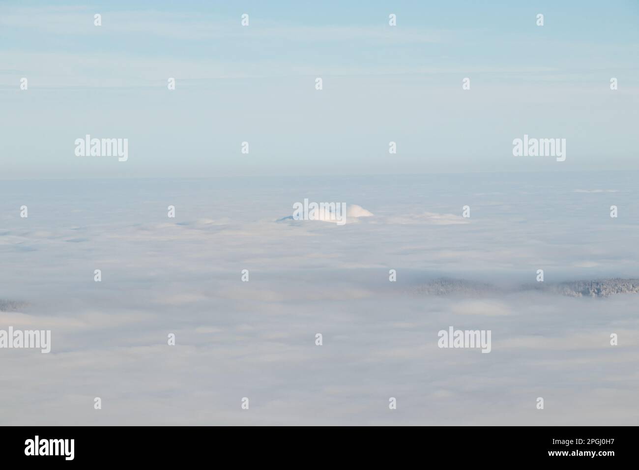 Blick auf den Gipfel des Mount Skalka in den Beskydy Mountains unter dem Deckmantel von dickem weißem Nebel in den Morgenstunden. Schneebedeckte Hügel mit Wolken. Über mir zu sein Stockfoto