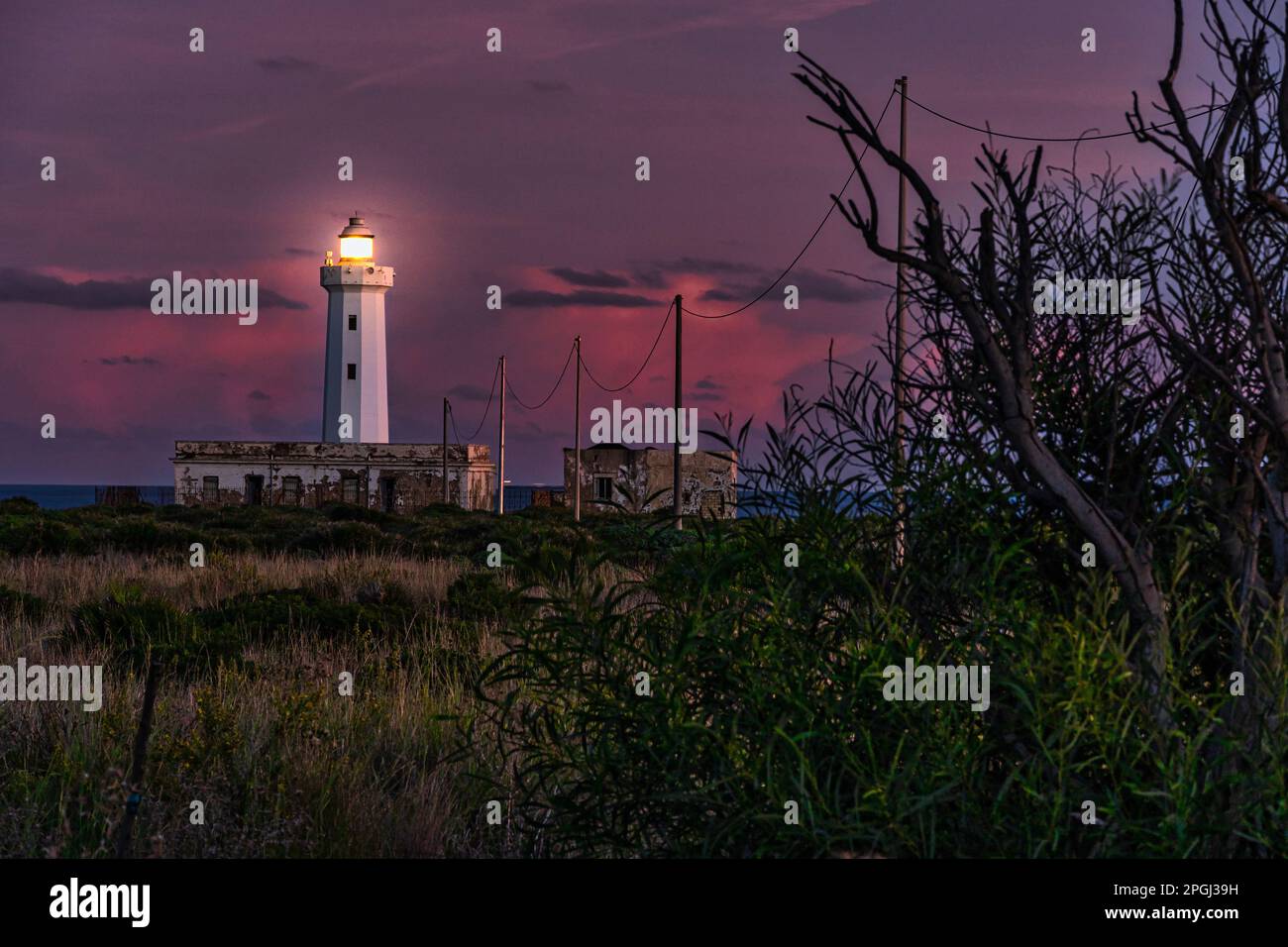 Der Leuchtturm von Capo Murro di Porco beleuchtet bei Sonnenuntergang. Plemmirio-Meeresschutzgebiet auf der Halbinsel Maddalena. Syrakus, Sizilien, Italien Stockfoto