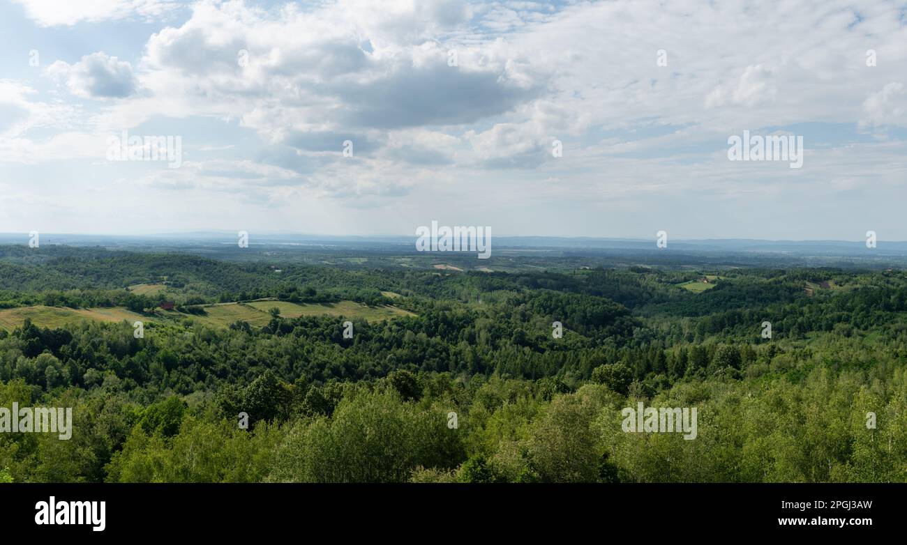 Hügeliges Landschaftspanorama, weit entferntes Tal voller Dunst, verstreute Dörfer und üppige Wälder Stockfoto