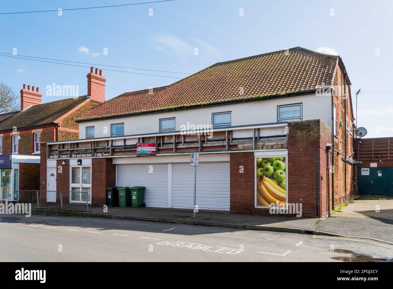 Ein geschlossener McColl's Lebensmittelladen in Norfolk Village in Heacham, jetzt als Einzelhandelseinheit mit Lagerraum zu vermieten. Stockfoto