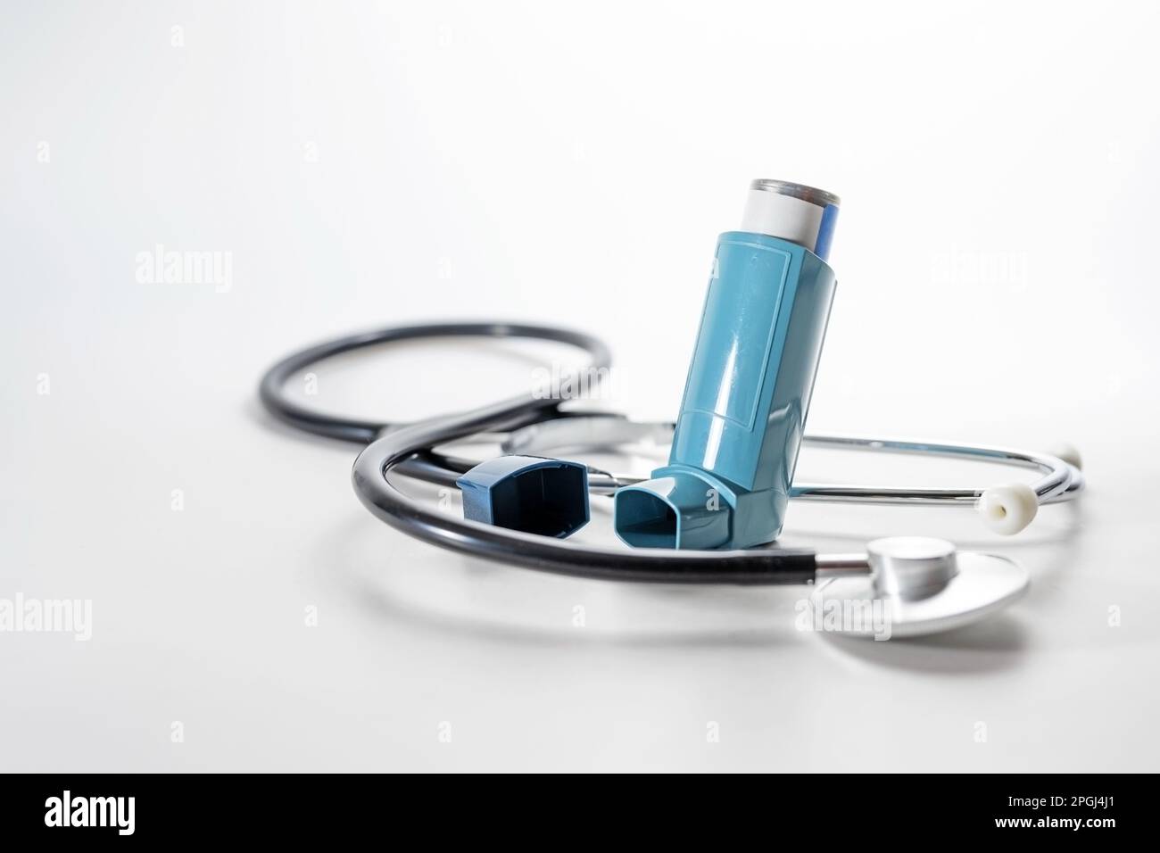 Dosierinhalator, auch bekannt als Pumpe oder Allergiespray für Asthma oder COPD und ein verschwommenes Stethoskop, medizinische Geräte, Kopierraum, ausgewählter Fokus, nar Stockfoto