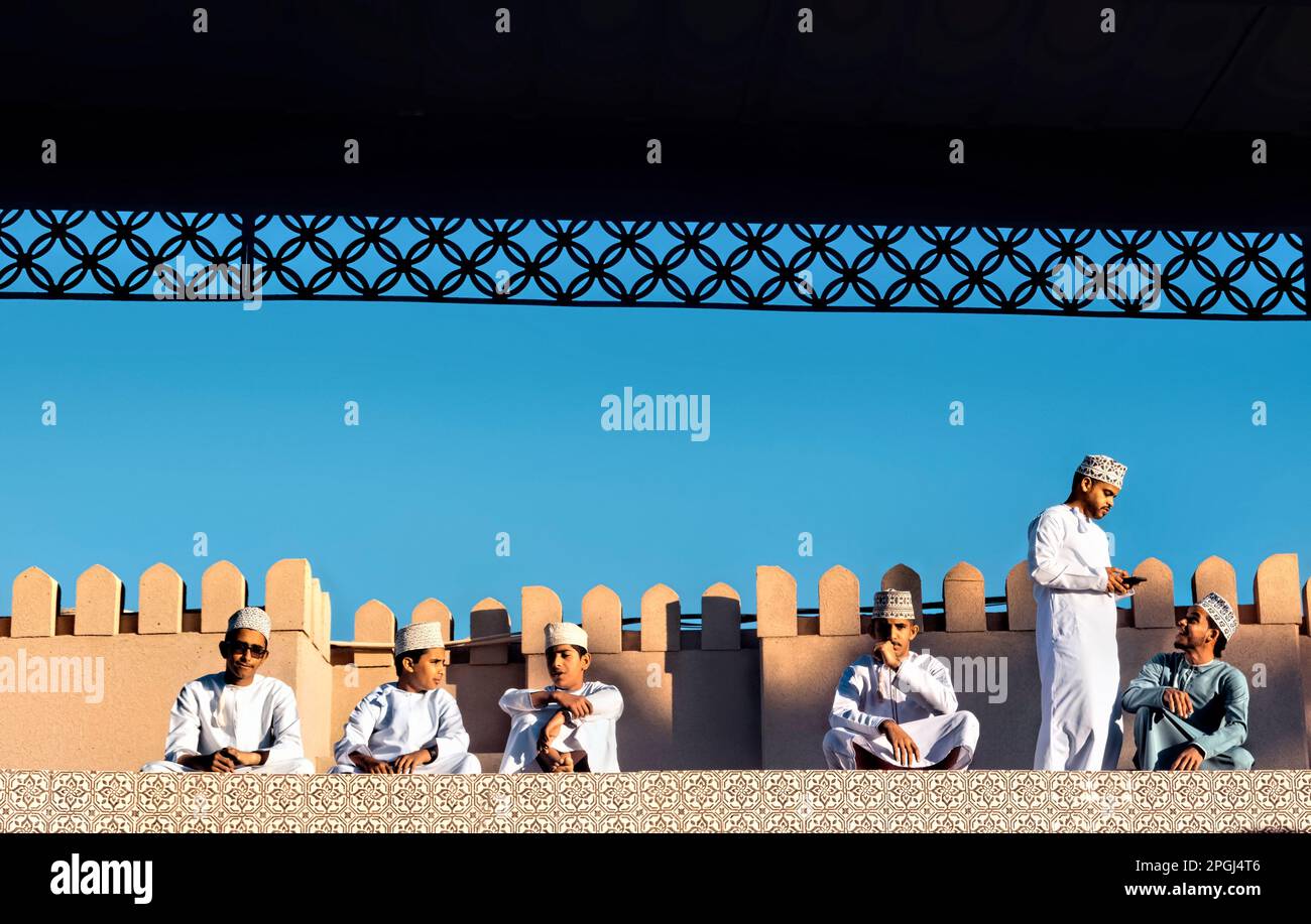 Jungs in traditionellen Kleidern auf dem Dach des Ziegenmarkts, Nizwa, Oman Stockfoto