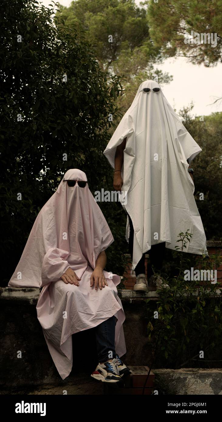 Zwei Leute, die an Halloween in weißen Laken gekleidet sind, die einem Geist  ähneln, mit Sonnenbrille Stockfotografie - Alamy