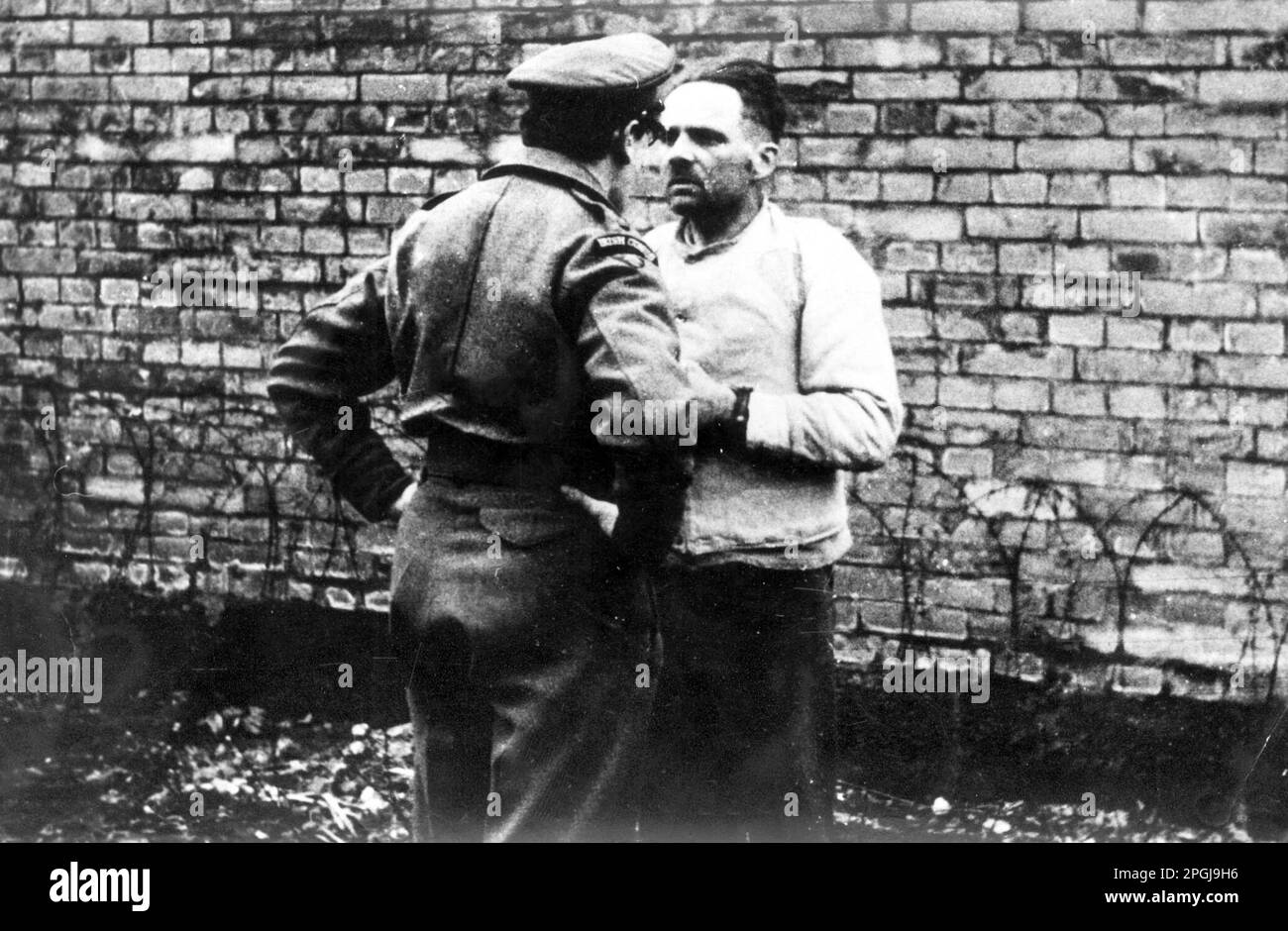 Rudolf Franz Ferdinand Hoss erster Kommandant von Auschwitz unter Gefangennahme und vor einem britischen Offizier vor dem Internationalen Militärprozess in Nürnburg. Er wurde am 16. April 1947 hingerichtet Stockfoto