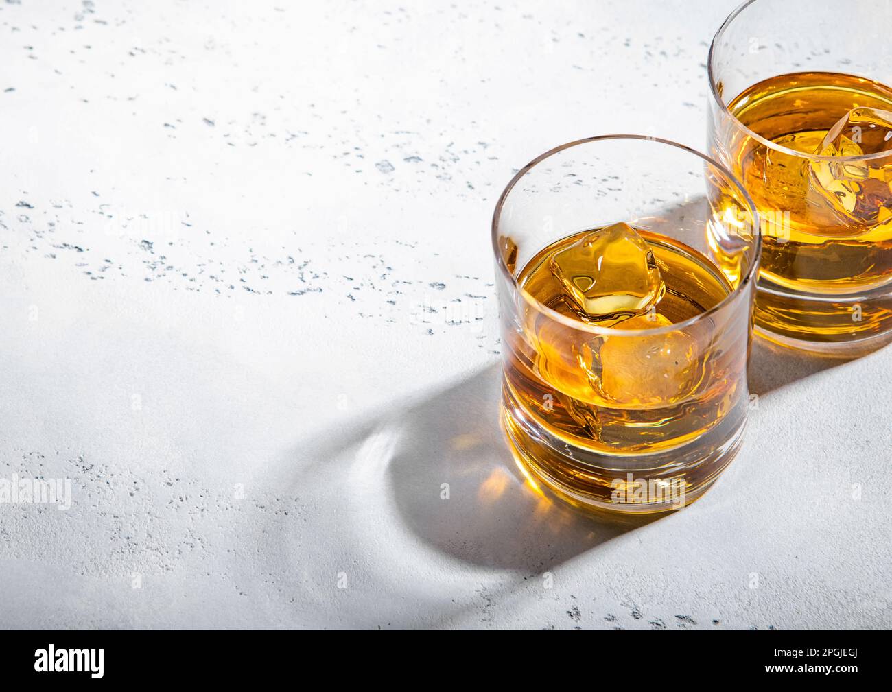 Zwei Whiskey-Gläser mit Eiswürfeln auf hellem Hintergrund. Makro Stockfoto