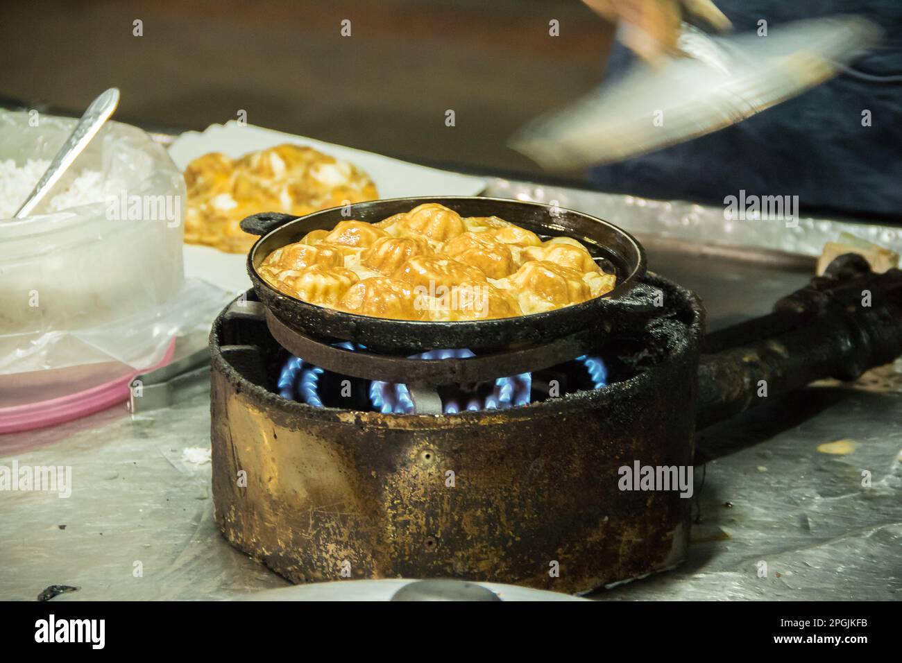 Roti in einer tiefen Bratpfanne, mit Granulatzucker bestreut und mit gesüßter Kondensmilch Stockfoto