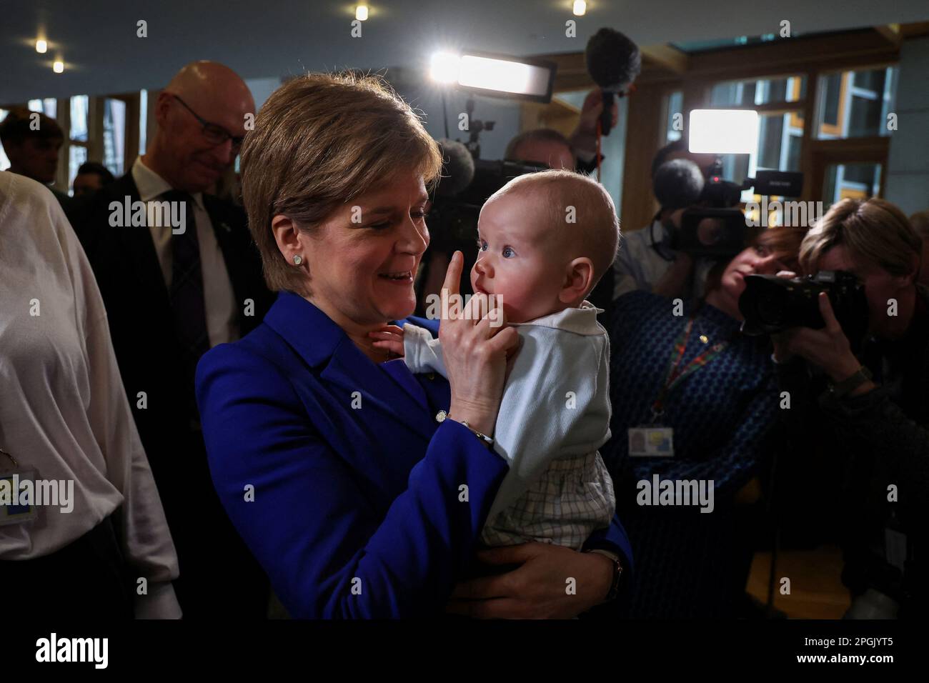 Schottlands erster Minister Nicola Sturgeon hält am Tag ihrer letzten ersten Minster's Questions im schottischen Parlament in Holyrood, Edinburgh, Schottland, Großbritannien, ein Kind fest, März 23. 2023. REUTERS/Russell Cheyne Stockfoto