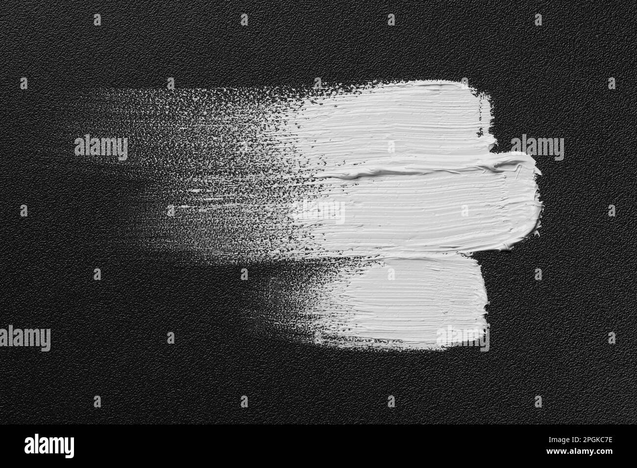 Striche mit weißer Ölfarbe auf schwarzer Leinwand, Draufsicht Stockfoto