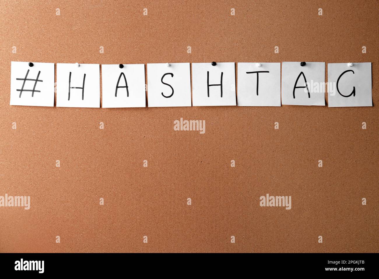 Weiße Notizzettel mit Wort-Hashtag und Symbol auf Korkbrett. Platz für Text Stockfoto