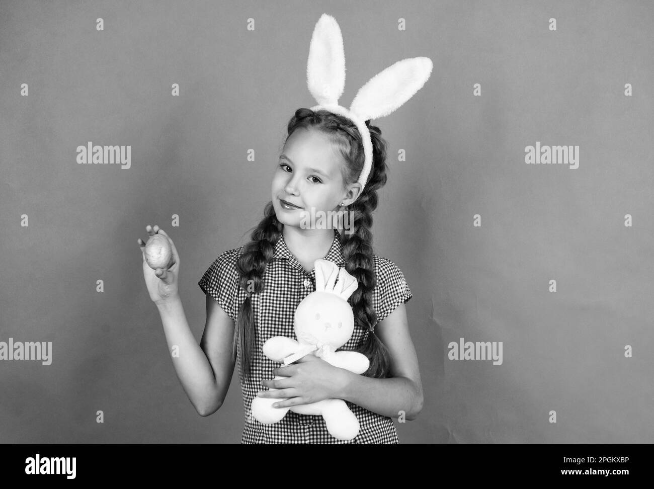 Köstliche Leckereien. Glückliches Mädchen hält osterhase Spielzeug. Kind tragen Hasenohren. Kind im Kaninchen Kostüm. Frühlingsurlaub Spaß. Frohe Ostern. Eiersuche begann Stockfoto