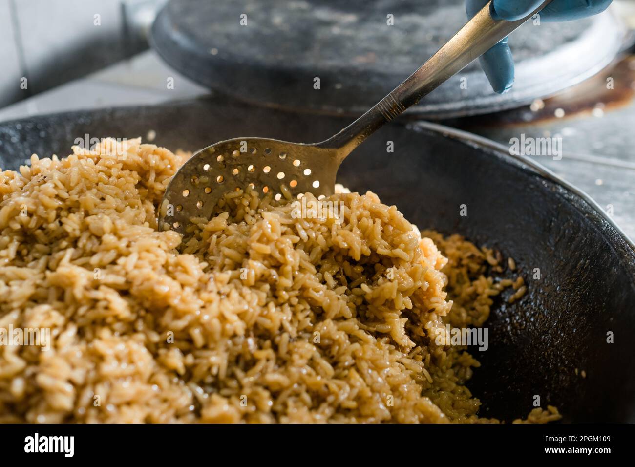 Koch bereitet traditionelles usbekisches Reisgericht zu Stockfoto