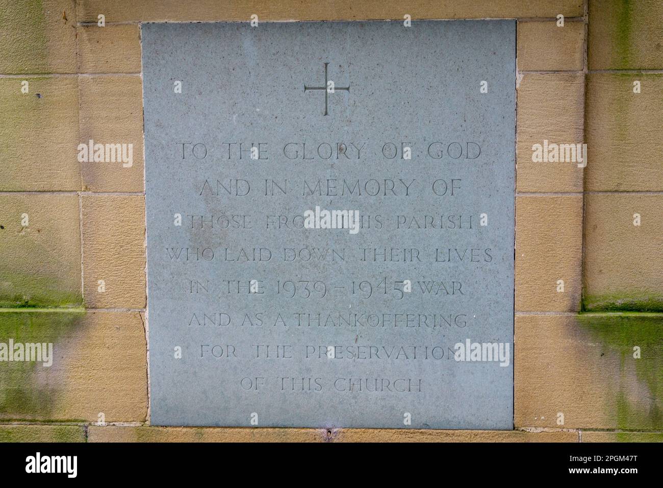 Stein in der Wand einer britischen christlichen Kirche zur Gedenkstätte des Zweiten Weltkriegs Stockfoto