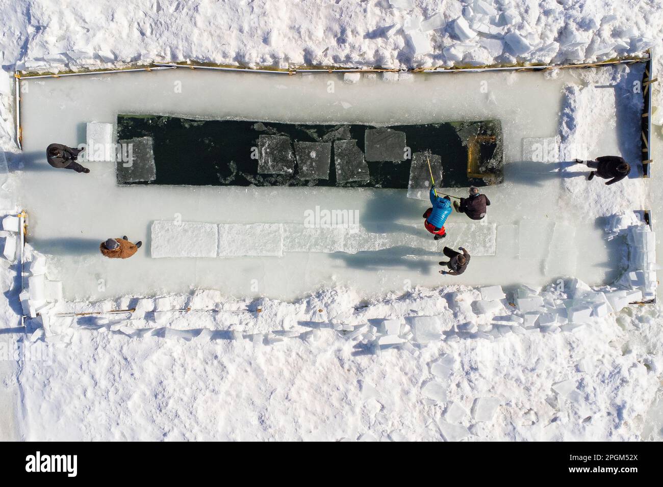 Eisblöcke werden aus einem See entfernt, bevor Eisschwimmer ein Bad im kalten Wasser südlich von Quebec City nehmen. 12. März 2023. Stockfoto