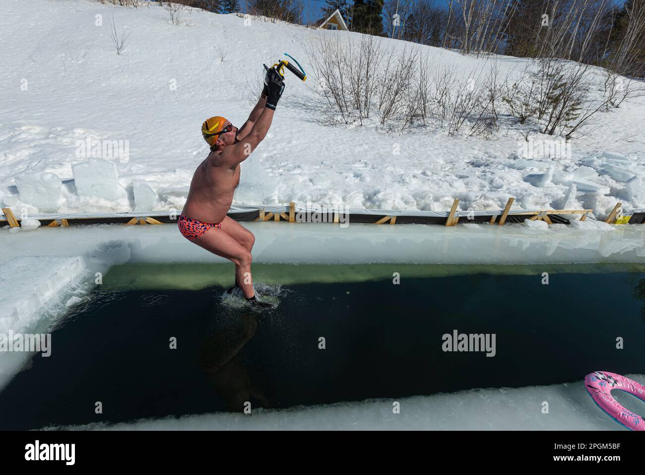 Nicolas Knap filmt sich selbst mit einer GoPro Kamera, während er am 5. März 2023 in einen zugefrorenen See südlich von Quebec City springt. Stockfoto