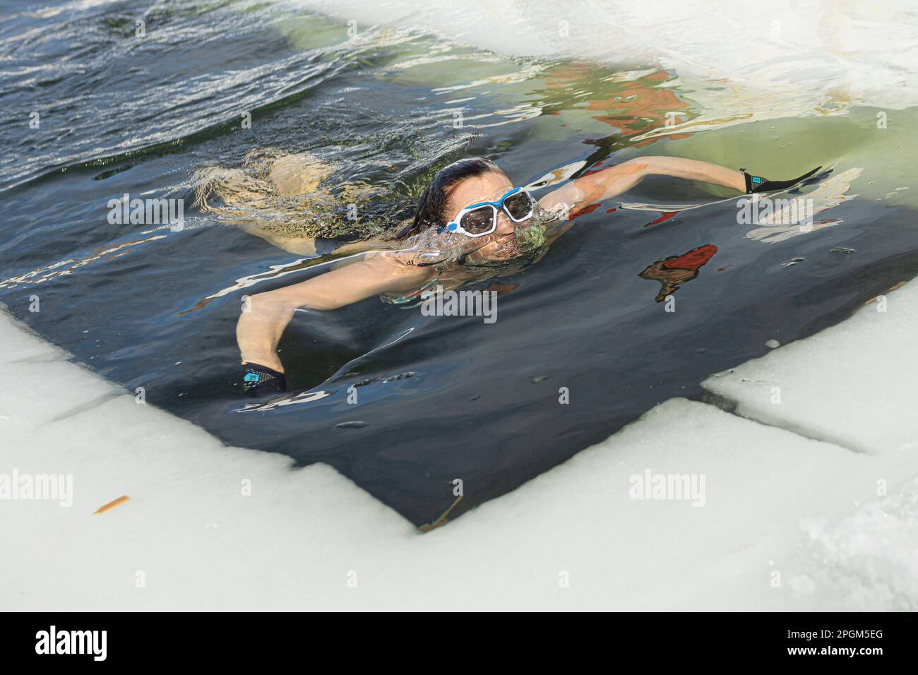 Manon Levesque schwimmt am 5. März 2023 in das kalte Wasser eines gefrorenen Sees südlich von Quebec City. Stockfoto