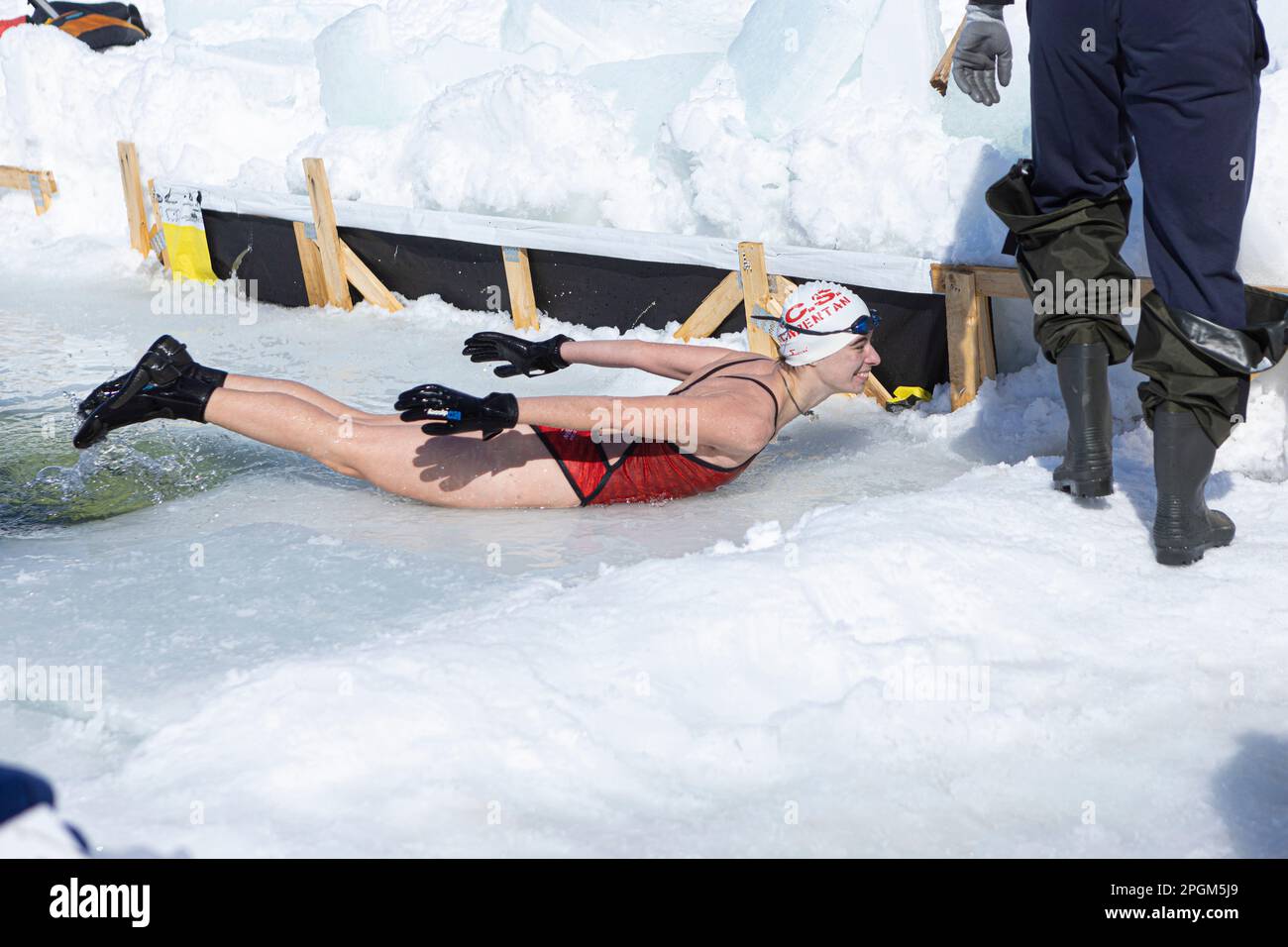Adele Luthi-Maire tritt am 5. März 2023 auf lustige Weise südlich von Québec aus dem kalten Wasser eines gefrorenen Sees auf. Stockfoto