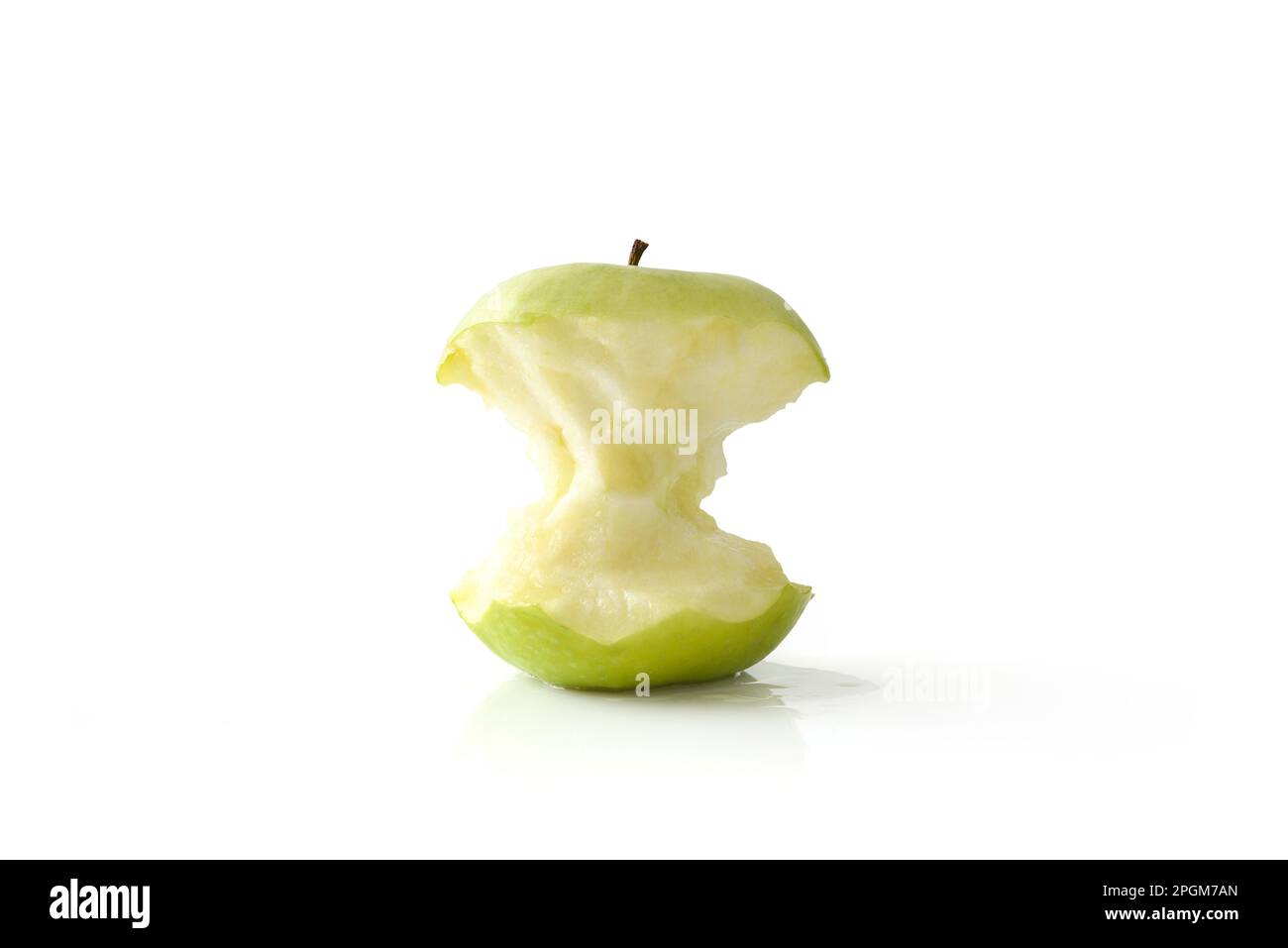 Schmackhafter, halb gefressener grüner Apfel reflektiert auf weißem Tisch und weiß isoliertem Hintergrund. Vorderansicht. Stockfoto