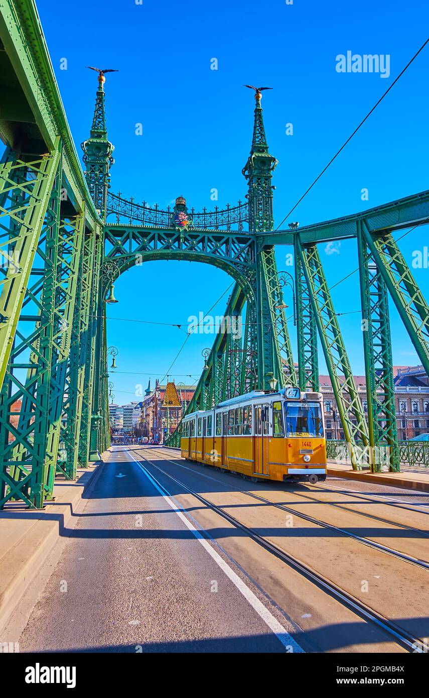 Straßenbahnverkehr auf der historischen Liberty Bridge, dekoriert mit ungarischem Wappen, Turul-Vögeln auf den Türmen und alten Straßenlaternen, Budapest, Ungarn Stockfoto