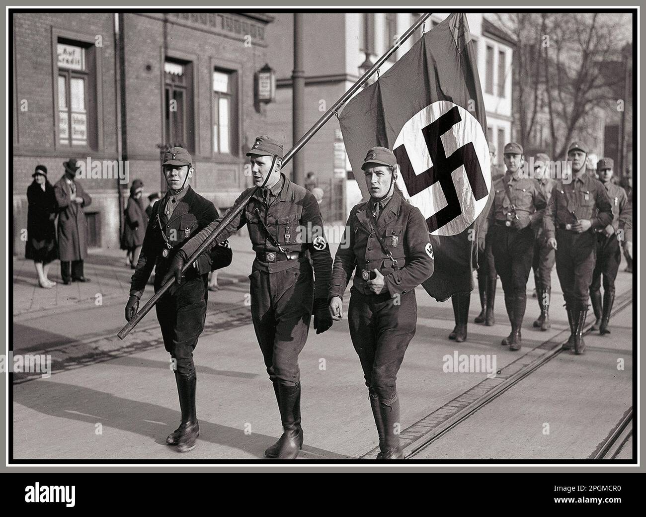 Deutsche Nazi-SA-Männer in Parade, Braunschweig, Nazi-Deutschland, 1932. April, mit Swastika-Flagge, die Soldaten der Nazi-Sturmabteilung der SA transportiert, marschieren durch eine deutsche Stadt im 1932. Nazi-Deutschland Stockfoto