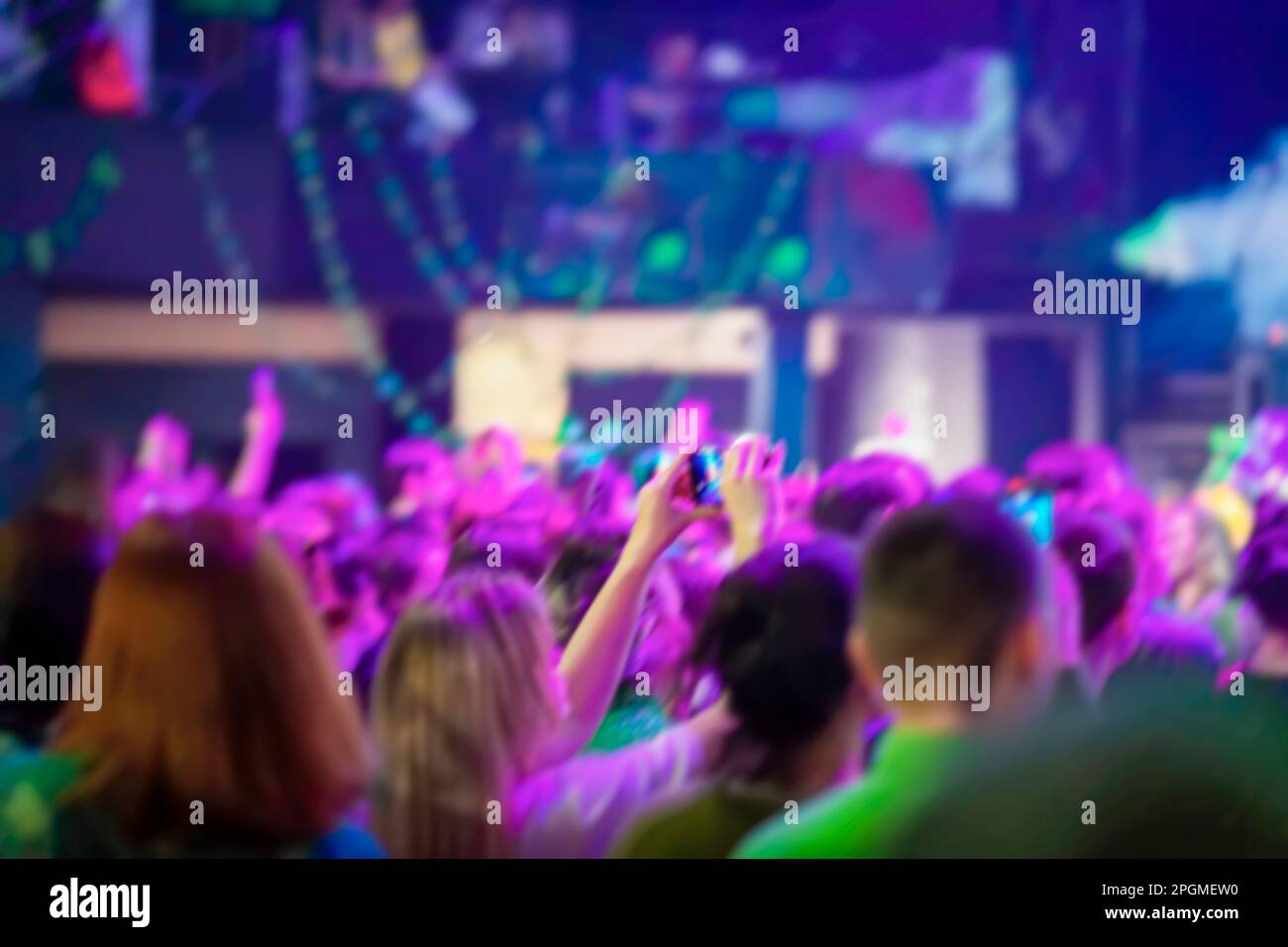 Verschwommener abstrakter Hintergrund von Fans der Livemusik, helles Neonlicht Stockfoto