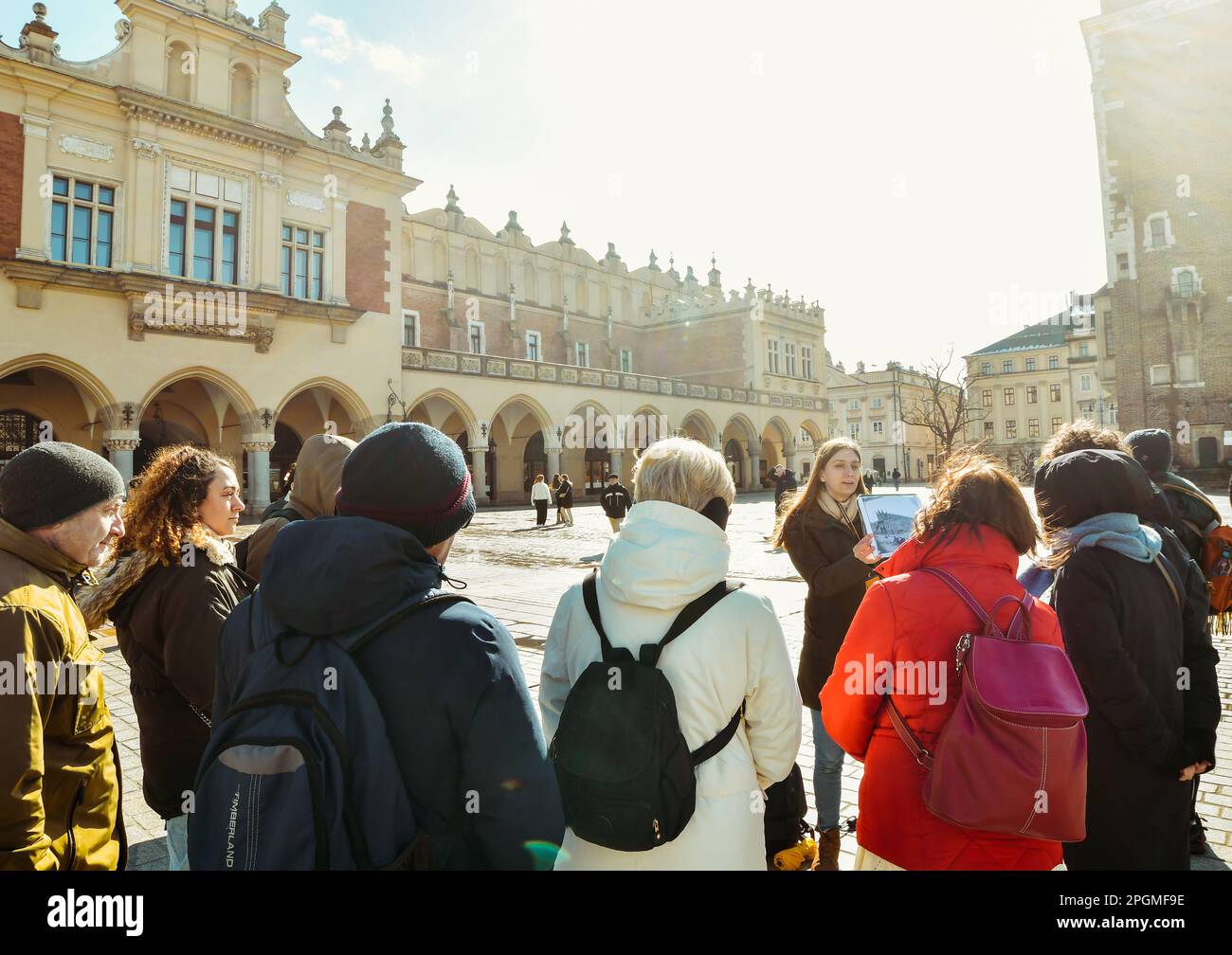 Krakau, Polen - 6. märz 2023: Reiseleiter mit Reisegruppe auf dem Hauptplatz in Krakau. Kostenlose Touristenwanderungen mit Einheimischen. Einzigartiges Erlebnis in New Cit Stockfoto