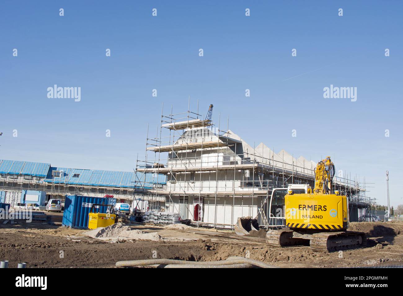 Nijmegen, Niederlande - 8. Februar 2023: Im Bau befindliche Terrassenhäuser mit gelbem Kran im Vordergrund Stockfoto