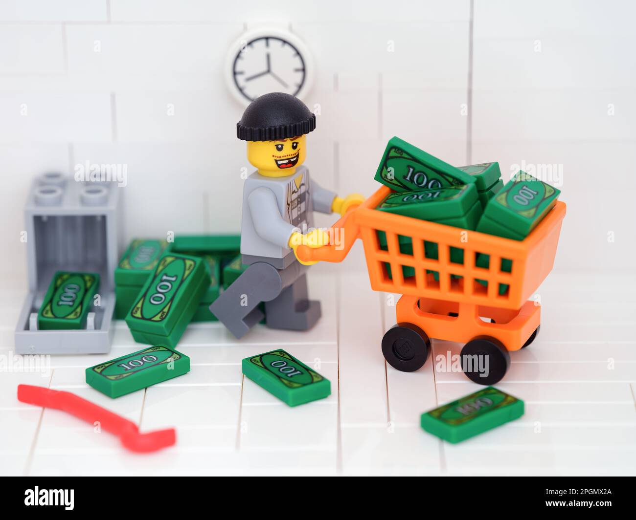 Tambov, Russische Föderation - 23. März 2023 Ein Lego-Einbrecher-Minifigure, der mit einem Einkaufswagen Geld aus einem Safe stiehlt. Stockfoto