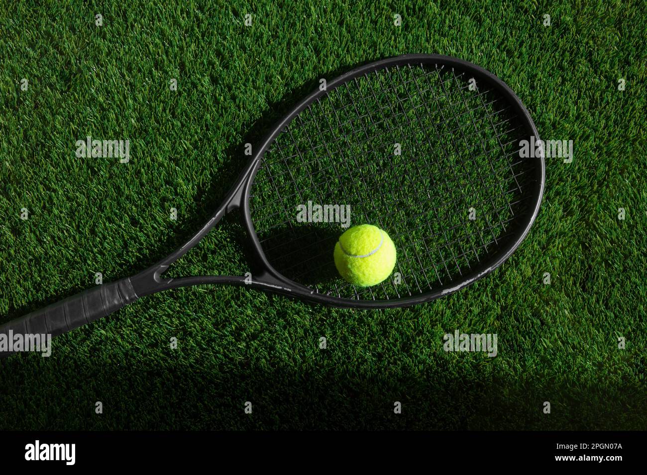 Draufsicht auf Tennisschläger und Ball aus grünem Gras. Horizontales Sport-Poster, Grußkarten, Kopfzeilen, Website Stockfoto