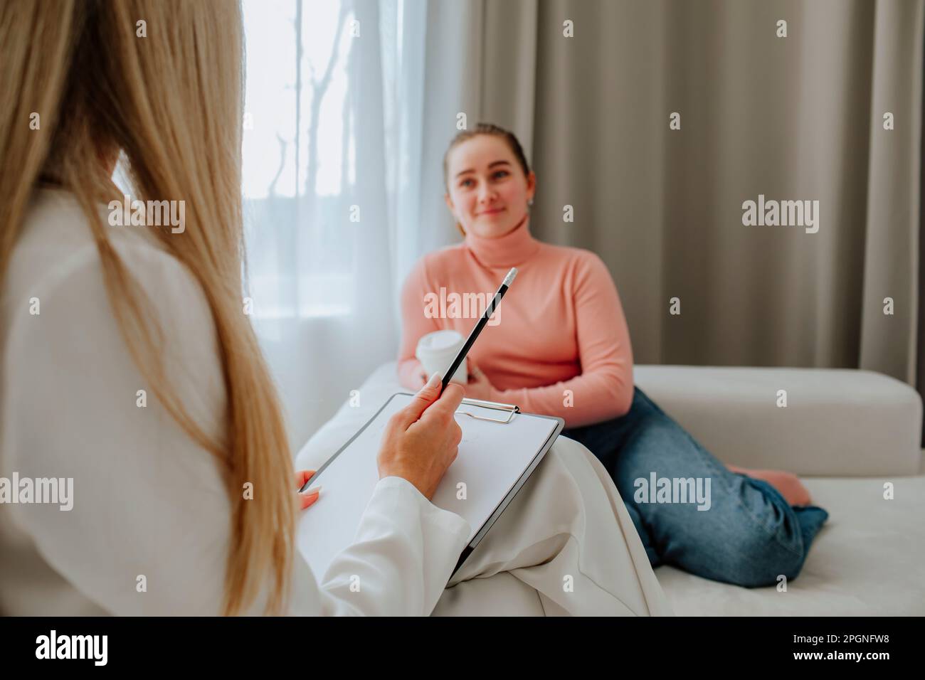 Mental Health Professional mit Clipboard, der den Patienten in der Praxis berät Stockfoto
