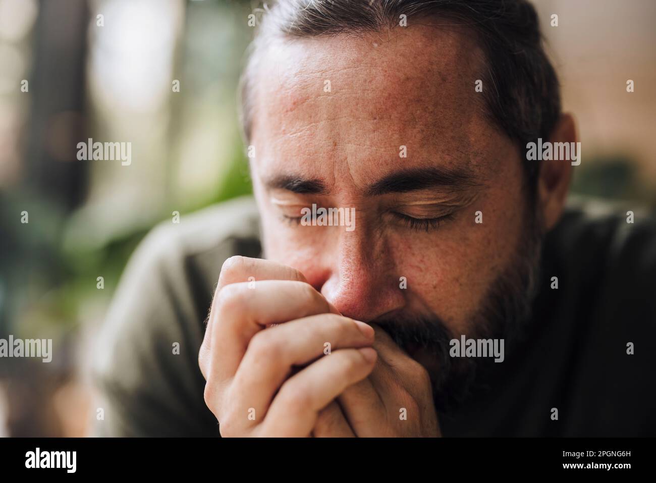 Reifer Mann mit geschlossenen Augen im Café Stockfoto