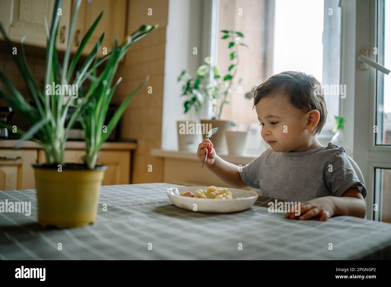 Ein Junge isst Nudeln zu Hause am Tisch Stockfoto