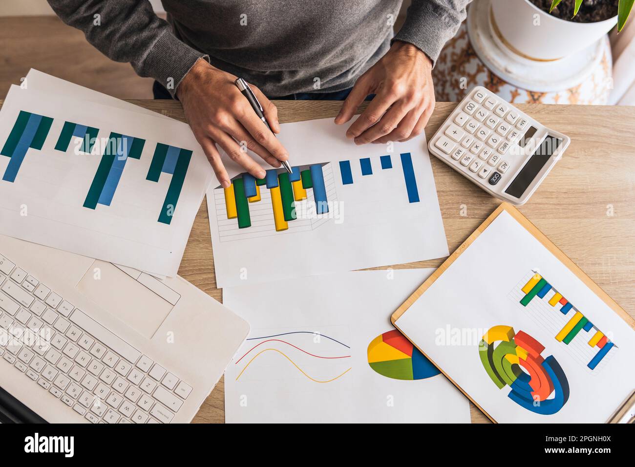 Hände eines Geschäftsmannes, der Diagramme und Diagramme am Schreibtisch im Büro analysiert Stockfoto