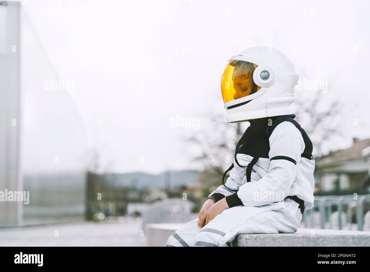 Ein Junge im Astronautenkostüm sitzt auf dem Sitz Stockfoto