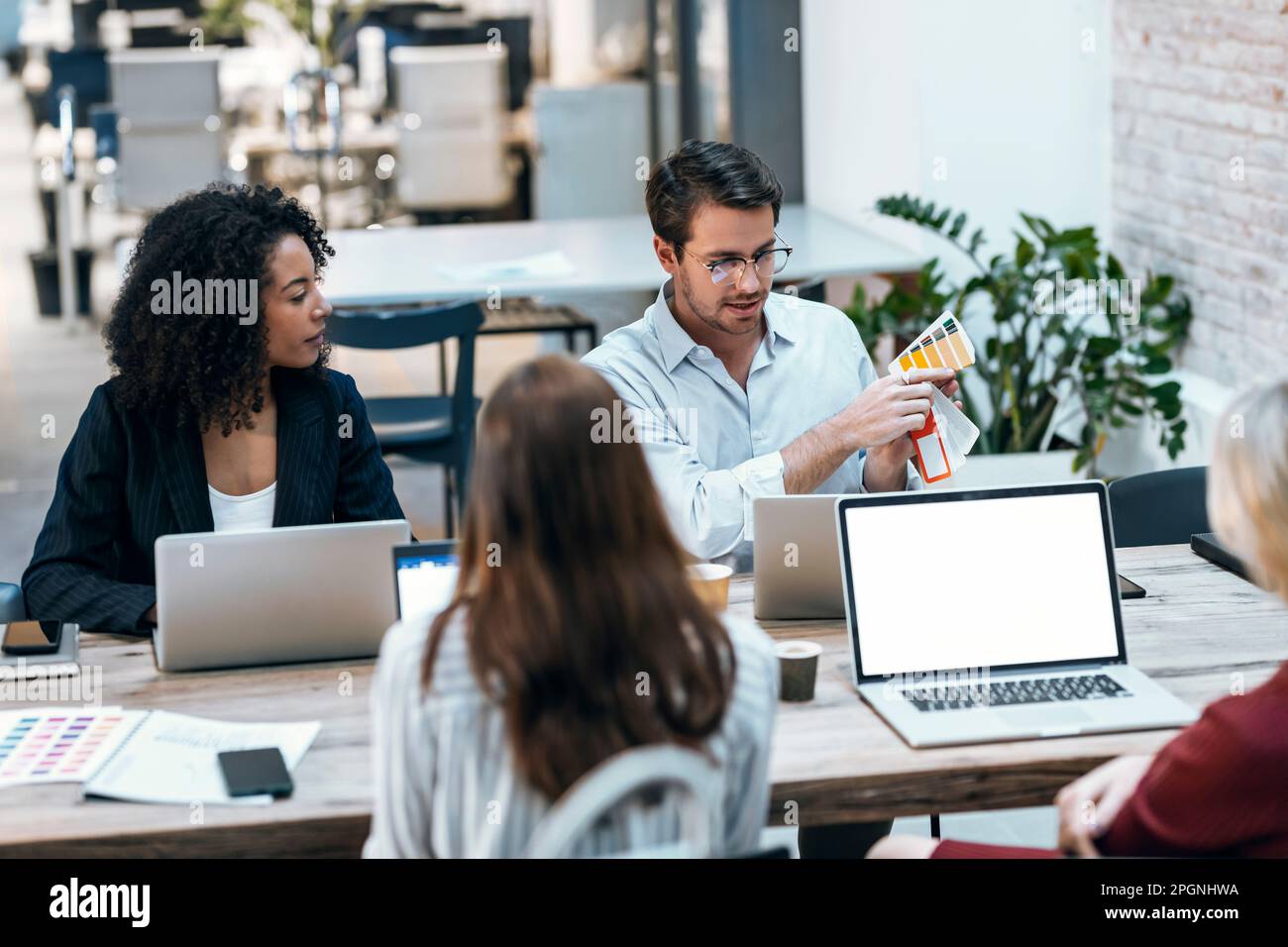 Designprofis diskutieren über Farbmuster im Büro Stockfoto