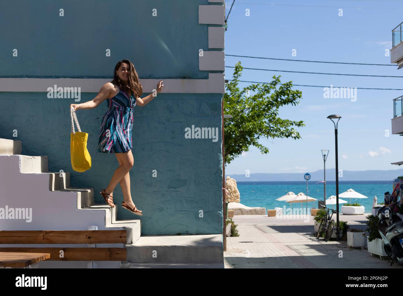 Eine Frau, die im Urlaub auf einer Treppe in der Nähe eines Gebäudes runterkommt Stockfoto