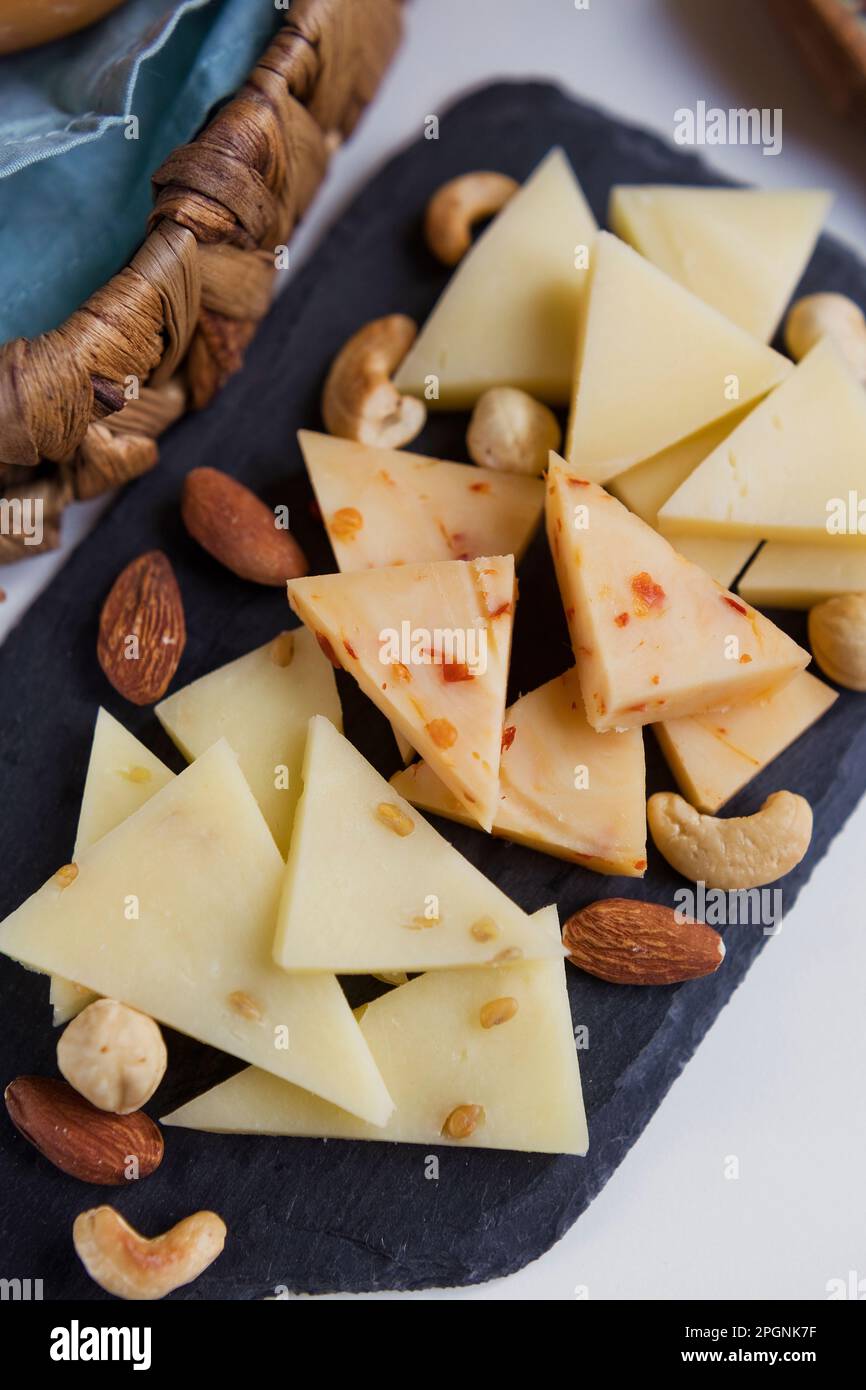Nüsse und Scheiben Caciocavallo-Käse auf dem Schneidebrett Stockfoto