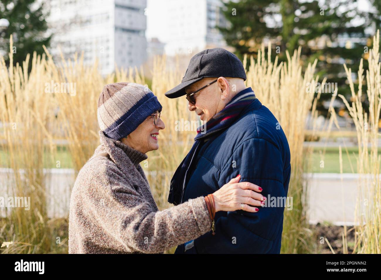 Glückliche Seniorin, die sich mit einem Mann im Park amüsiert Stockfoto
