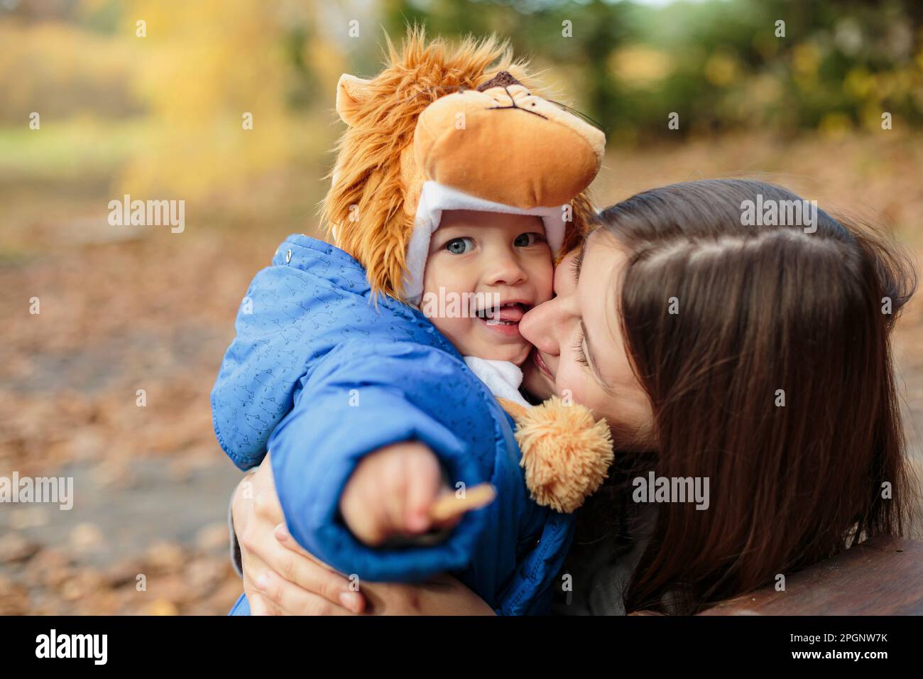 Mutter umarmt Sohn im Park Stockfoto