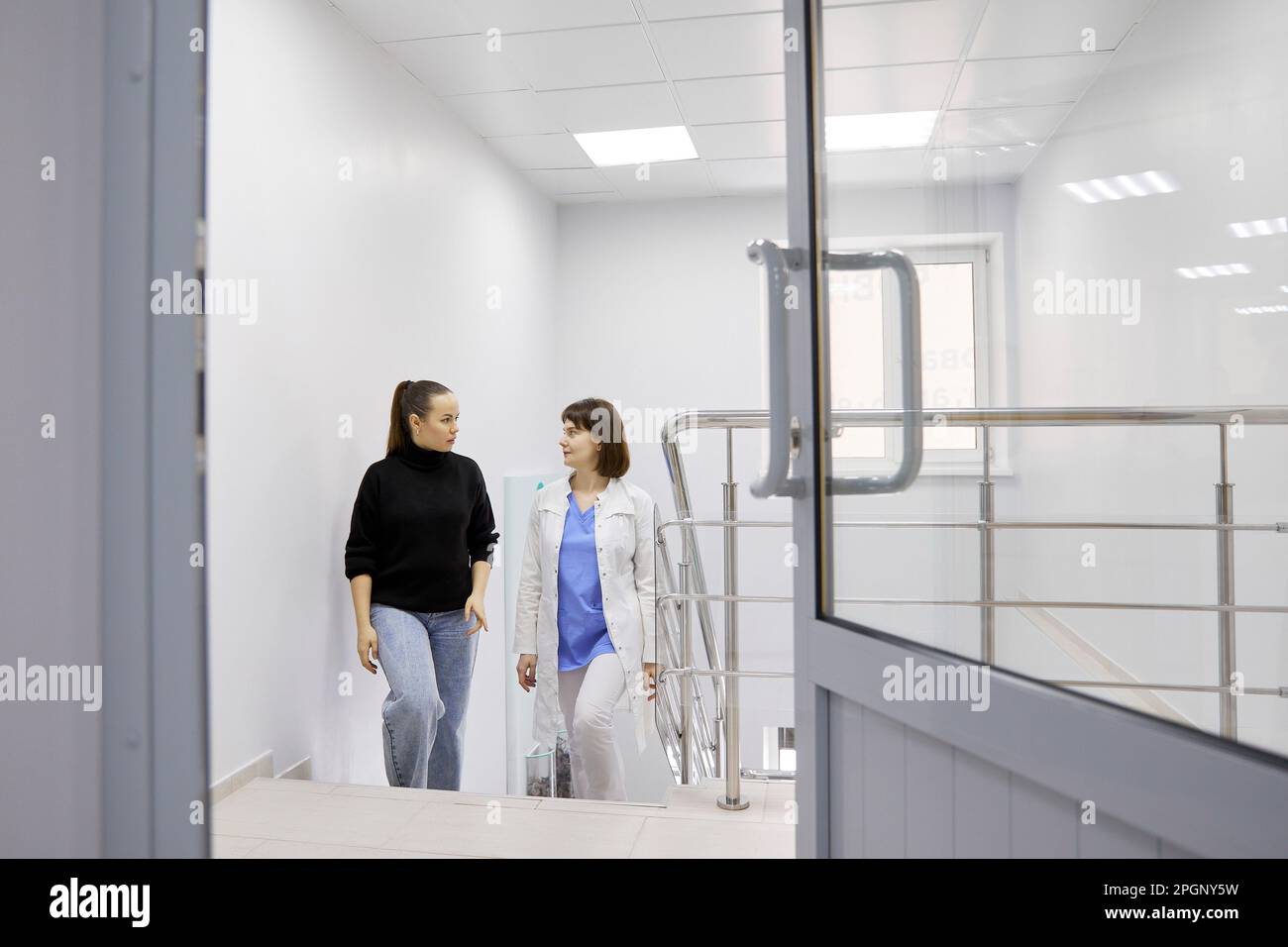 Arzt und Patient auf Treppen im Krankenhaus Stockfoto