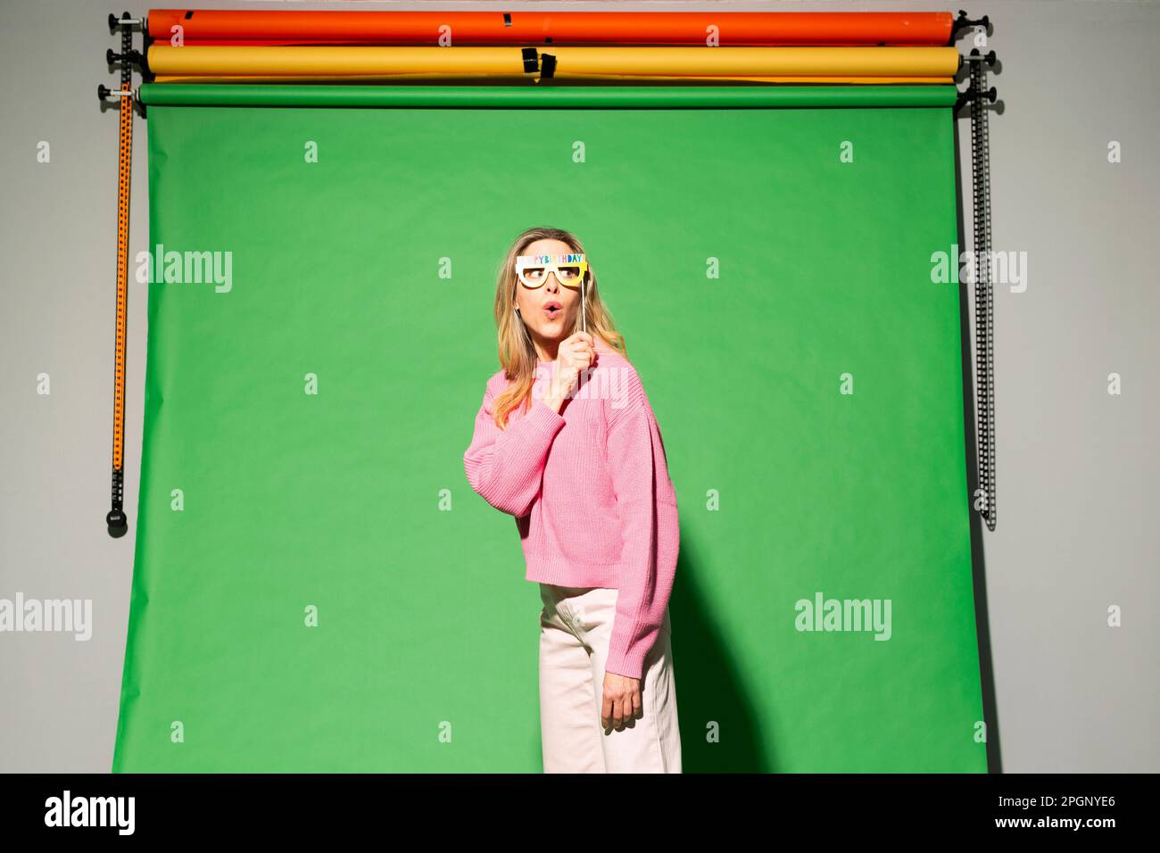 Eine Frau, die vor einem farbenfrohen Hintergrund steht Stockfoto