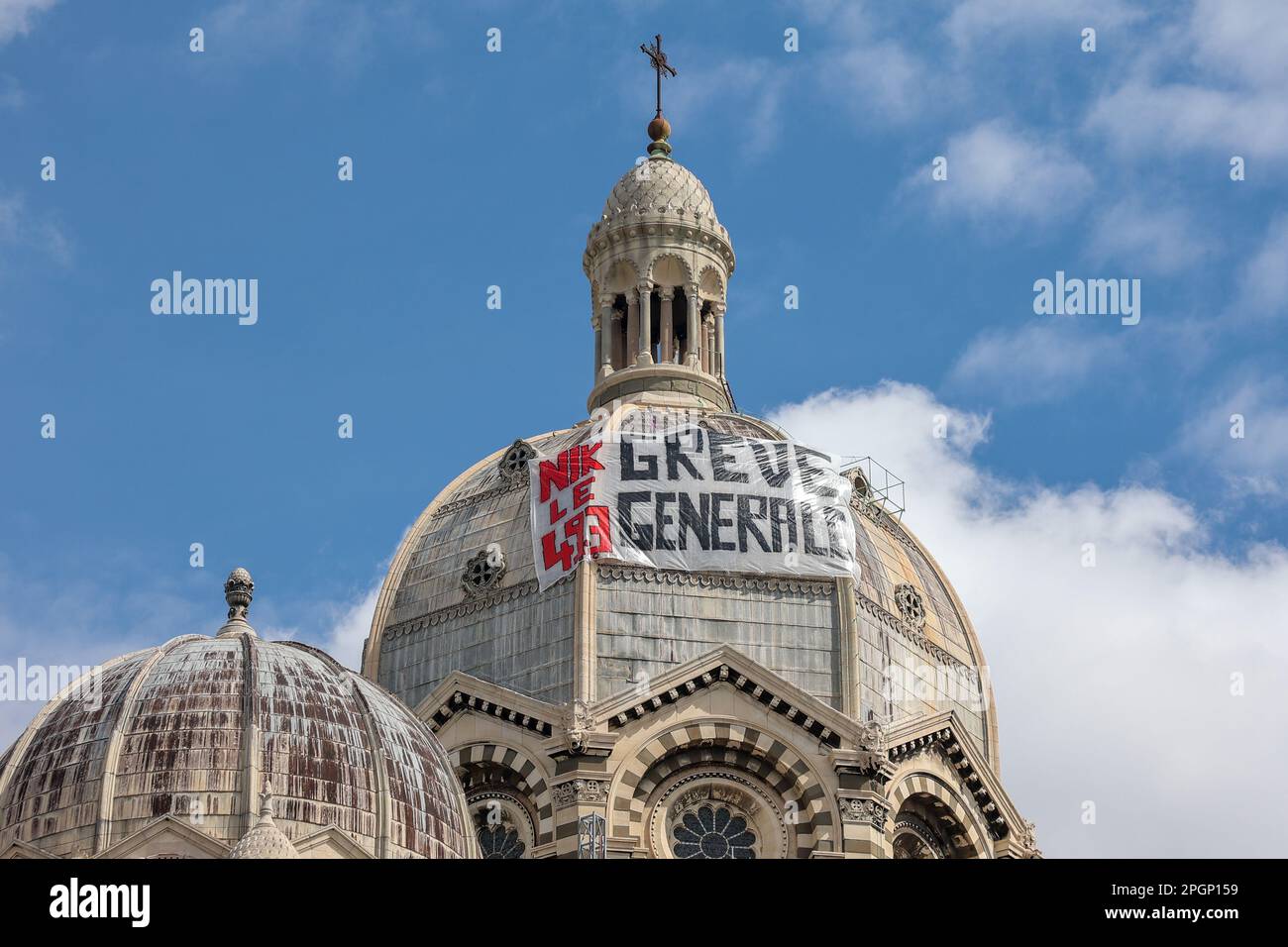 Marseille, Frankreich. 23. März 2023. Ein Banner, das einen Generalstreik fordert, hängt an der Kathedrale von Marseille am Rande der Demonstration gegen die Rentenreform. Die französischen Gewerkschaften haben eine 9.-tägige Aktion gegen die Rentenreform der französischen Regierung gefordert, mit der das Rentenalter von 62 auf 64 Jahre angehoben werden soll. Der französische Präsident Emmanuel Macron erzwang die Rentenreform mit Artikel 49,3 der französischen Verfassung. Artikel 49,3 erlaubt es der Regierung, die Verabschiedung eines Gesetzes ohne Zustimmung des parlaments zu erzwingen (Kreditbild: © Denis Thaust/SOPA Images via ZUMA Press Wire) REDAKTIONELLE VERWENDUNG Stockfoto