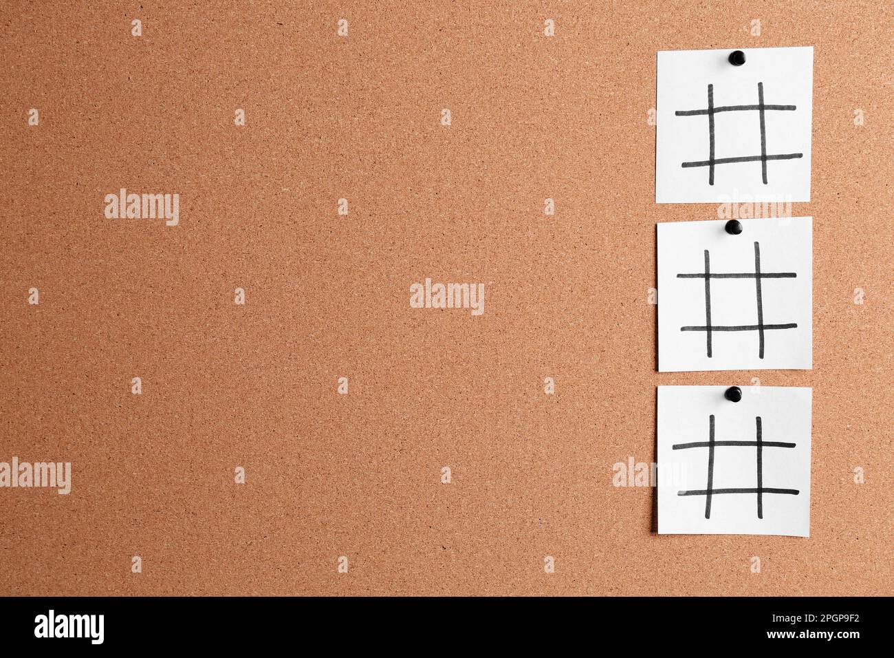 Weiße Notizzettel mit Hashtag-Symbolen auf Korkbrett. Platz für Text Stockfoto